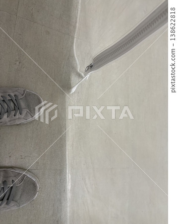 A minimalist overhead shot of gray sneakers and a white zipper. A minimalist overhead shot of gray sneakers and a white zipper. 138622818