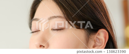 A woman meditating with her eyes closed A woman meditating with her eyes closed 138623390