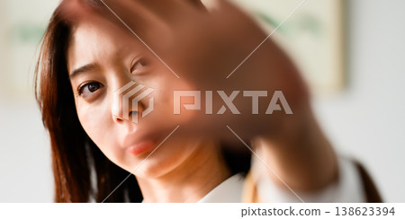 女人用手摀住臉，試圖遮掩。 138623394