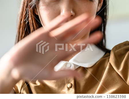一名女子在臉前揮開自己的手。 138623398
