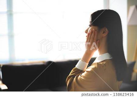 A woman puts her hand to her face and thinks. A woman puts her hand to her face and thinks. 138623416
