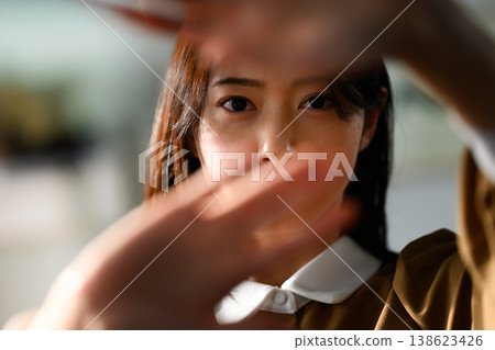 一名女子用手擋住臉。 138623426