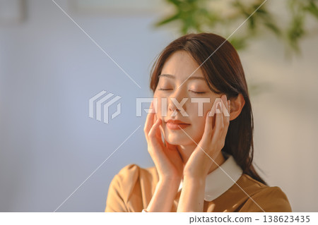 女人用手摀住臉放鬆一下。 138623435