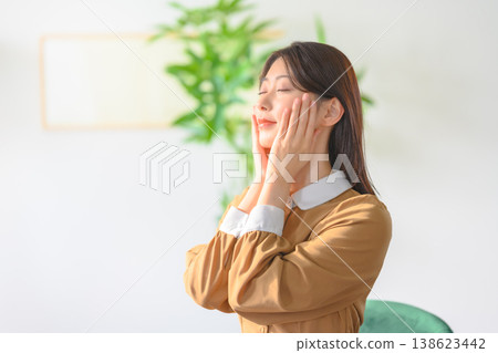 一位女士用手撫摸臉部進行護膚。 138623442