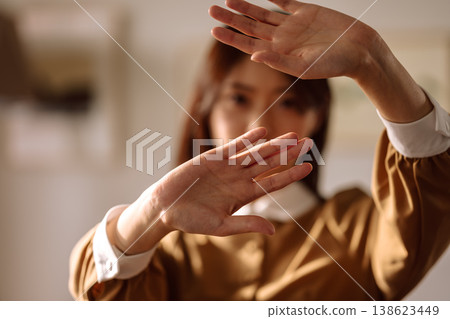 一名女子舉起雙手放在身前，表示拒絕。 138623449