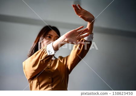 一個女人張開雙臂,擋住了某個東西。 一個女人張開雙臂,擋住了某個東西。 138623450