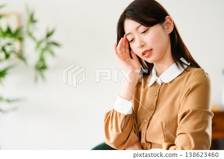 A woman puts her hand to her temple because she has a headache. 138623460