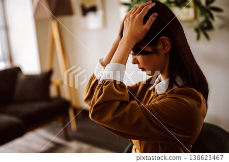一位神情憂鬱、雙手抱頭的女子。 138623467