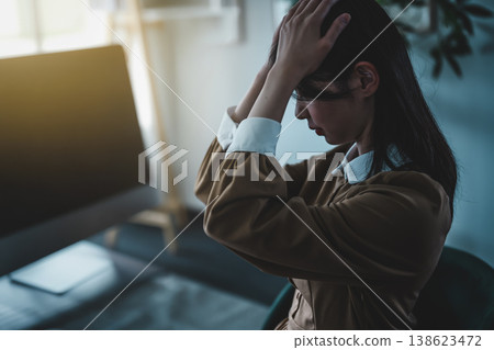 那名女子雙手抱頭，看起來很痛苦。 138623472