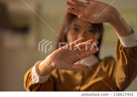 The woman holds her hands out in front of her to refuse. 138623492