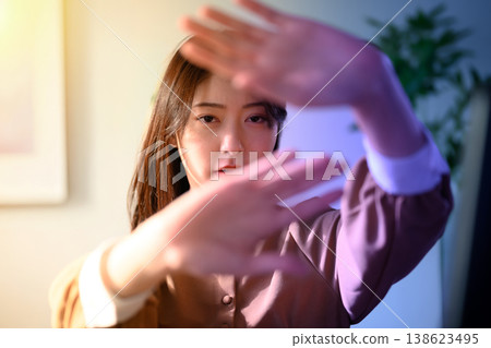 A woman covering her face with both hands. 138623495
