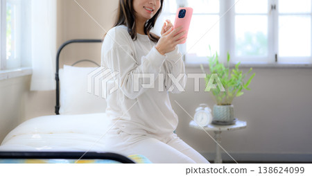 A woman watching a smartphone in bed A woman watching a smartphone in bed 138624099