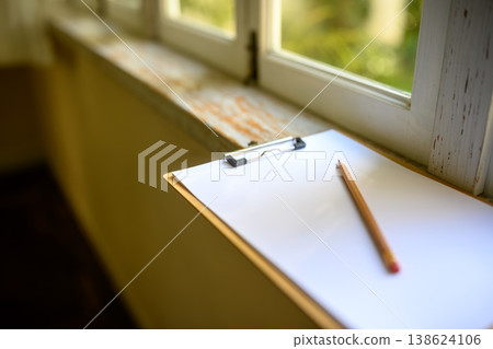 A clipboard and pencil by the window A clipboard and pencil by the window 138624106