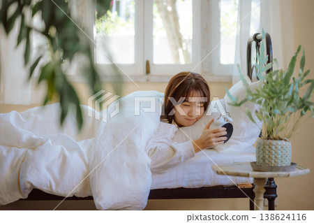 A woman with an alarm clock A woman with an alarm clock 138624116