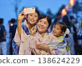A mother and daughter take photos with their smartphones to capture memories of the summer festival. 138624229