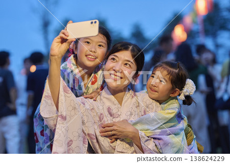 一對母女用智慧型手機拍照,記錄下夏日節日的美好回憶。 一對母女用智慧型手機拍照,記錄下夏日節日的美好回憶。 138624229