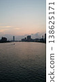 A boat heads out to sea in the city at dawn. 138625171