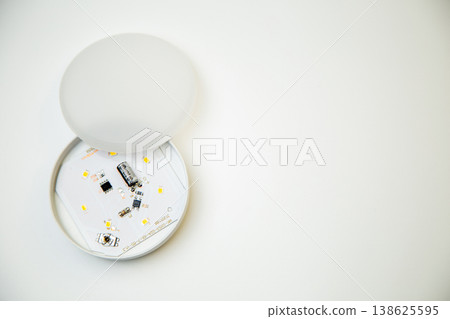 A small open light bulb with microcircuits and light elements inside lies on the side on a white background with space for text. Lighting concept, LED lamps. High quality photo  138625595