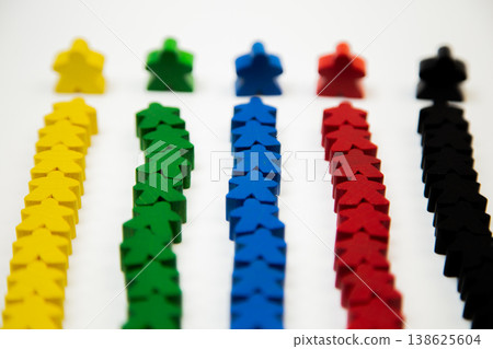 Side view of rows of wooden multi-colored men, with a large man at the base, divided into teams on a white background. The concept of team competitions, community groups, people. High quality photo Side view of rows of wooden multi-colored men, with a large man at the base, divided into teams on a white background. The concept of team competitions, community groups, people. High quality photo 138625604