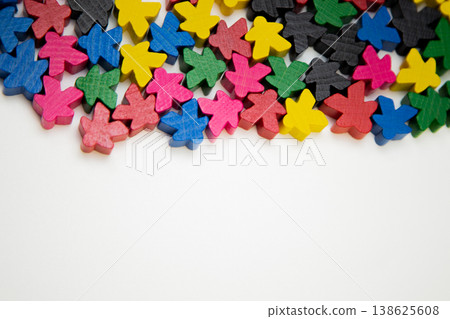 Small colorful wooden men lie on top on a white background with space for text. The concept of people, society, meetings, meetings. High quality photo Small colorful wooden men lie on top on a white background with space for text. The concept of people, society, meetings, meetings. High quality photo 138625608