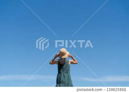 A woman wearing a hat under a blue sky 138625808