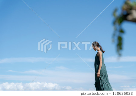 一位身著洋裝的女子在藍天下行走 一位身著洋裝的女子在藍天下行走 138626028