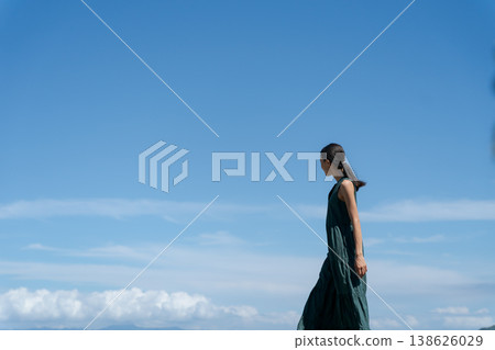 一位身著洋裝的女子在藍天下行走 一位身著洋裝的女子在藍天下行走 138626029