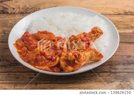 Chicken wings simmered in tomato sauce over rice Chicken wings simmered in tomato sauce over rice 138626150