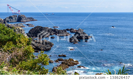 一艘打撈船和一艘拖船沿著和歌山縣本州島最南端的鹽之岬海岸航行。 138626437
