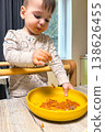 Toddler self-feeding messy meal in high chair 138626455
