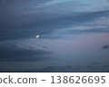 傍晚的月亮在雲層間緩緩移動。 138626695