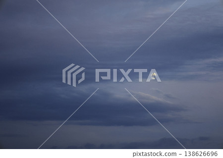 傍晚的月亮在雲層間緩緩移動。 138626696
