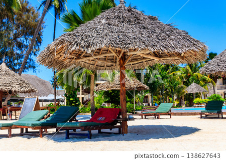 Sun umbrellas and chaise lounges on tropical beach. Concept of rest, relaxation, holidays, resort 138627643