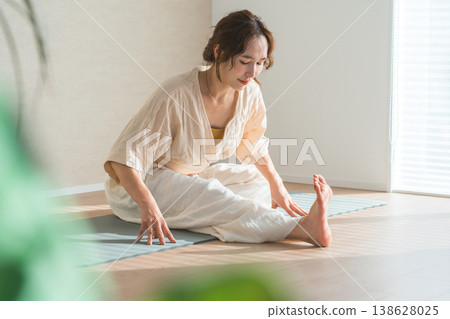 A woman doing yoga in the living room of her home (relaxation, health care, meditation) A woman doing yoga in the living room of her home (relaxation, health care, meditation) 138628025