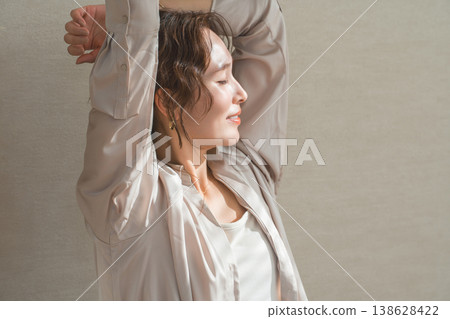 一位神態放鬆的女士在客廳裡沐浴在陽光下。 138628422