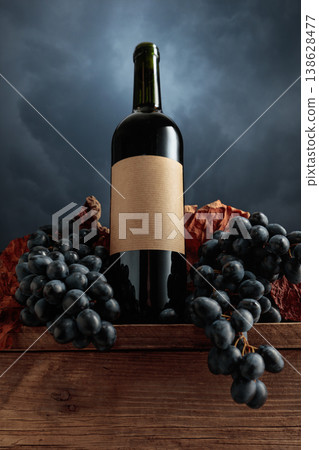 Red wine bottle with blue grapes on a background of cloudy sky. Red wine bottle with blue grapes on a background of cloudy sky. 138628477