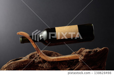 Bottle of red wine with empty label on a old wooden snag. Bottle of red wine with empty label on a old wooden snag. 138628498