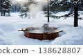 Wooden hot tub in snowy winter forest with steam rising and warm drinks on the side 138628807