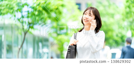 A woman/businesswoman talking on her smartphone in an office district (for LP/banner ads) 138629302