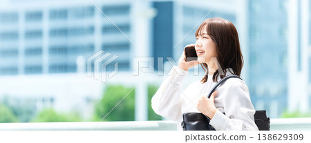 A woman/businesswoman talking on her smartphone in an office district (for LP/banner ads) A woman/businesswoman talking on her smartphone in an office district (for LP/banner ads) 138629309