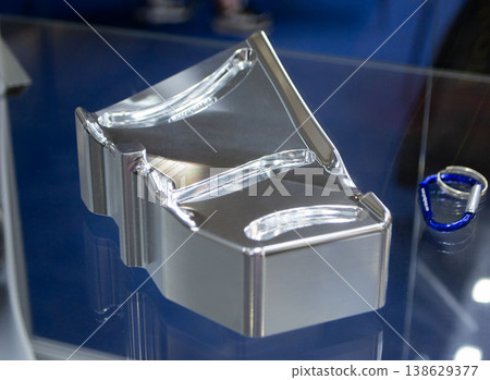 Metal part manufactured using CNC machining. Metal part made by metalworking CNC machine from a solid piece of metal. Polished aluminum or stainless steel. High-precision milling followed by polishing 138629377