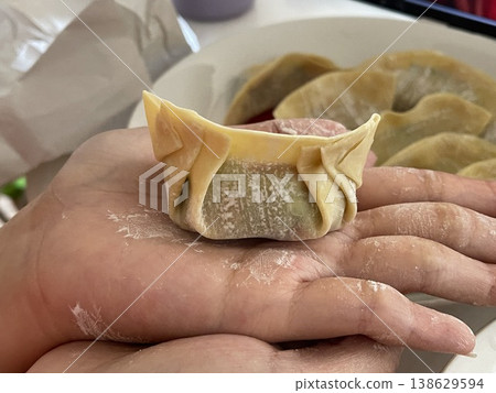 Close Up Of Hand Holding Newly Folded Pork And Vegetable Dumpling 138629594
