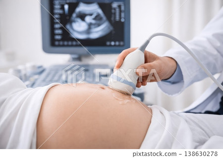 Doctor performing ultrasound examination on pregnant woman belly in modern clinic Doctor performing ultrasound examination on pregnant woman belly in modern clinic 138630278