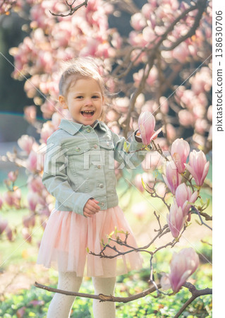 Little girl in a blooming magnolia garden in Prague enjoying the spring atmosphere. A moment of childhood wonder and connection with nature Little girl in a blooming magnolia garden in Prague enjoying the spring atmosphere. A moment of childhood wonder and connection with nature 138630706