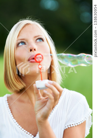 Woman, thinking and blowing bubbles in nature for fun day or playing at outdoor park. Face of female person or blonde in wonder with stick or wand to blow bubble on playful holiday or summer break 138630954