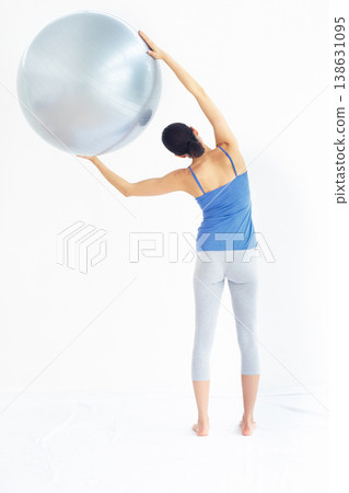 Woman, exercise or ball with back for yoga, exercise or workout on muscle, posture and healthy body. Person, arm or stretching for pilates, training or fitness with sportswear and technique in studio Woman, exercise or ball with back for yoga, exercise or workout on muscle, posture and healthy body. Person, arm or stretching for pilates, training or fitness with sportswear and technique in studio 138631095