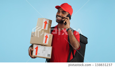Man, logistics and courier with cellphone in communication to client, delivery or boxes in studio. Indian person, supply chain and cargo in conversation with customer, packages and blue background Man, logistics and courier with cellphone in communication to client, delivery or boxes in studio. Indian person, supply chain and cargo in conversation with customer, packages and blue background 138631237