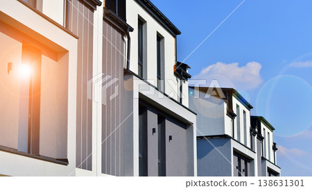 The real estate market in the suburbs. Terraced family homes in newly developed housing estate. New single family houses in a new development area. Residential homes with modern facade. The real estate market in the suburbs. Terraced family homes in newly developed housing estate. New single family houses in a new development area. Residential homes with modern facade. 138631301