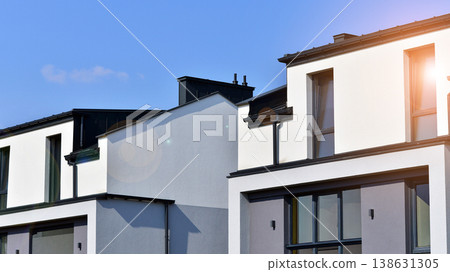 The real estate market in the suburbs. Terraced family homes in newly developed housing estate. New single family houses in a new development area. Residential homes with modern facade. The real estate market in the suburbs. Terraced family homes in newly developed housing estate. New single family houses in a new development area. Residential homes with modern facade. 138631305