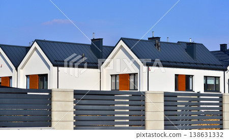 The real estate market in the suburbs. Terraced family homes in newly developed housing estate. New single family houses in a new development area. Residential homes with modern facade. The real estate market in the suburbs. Terraced family homes in newly developed housing estate. New single family houses in a new development area. Residential homes with modern facade. 138631332